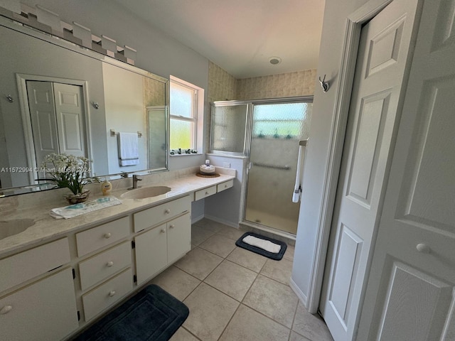 bathroom featuring a shower with door, tile flooring, and vanity