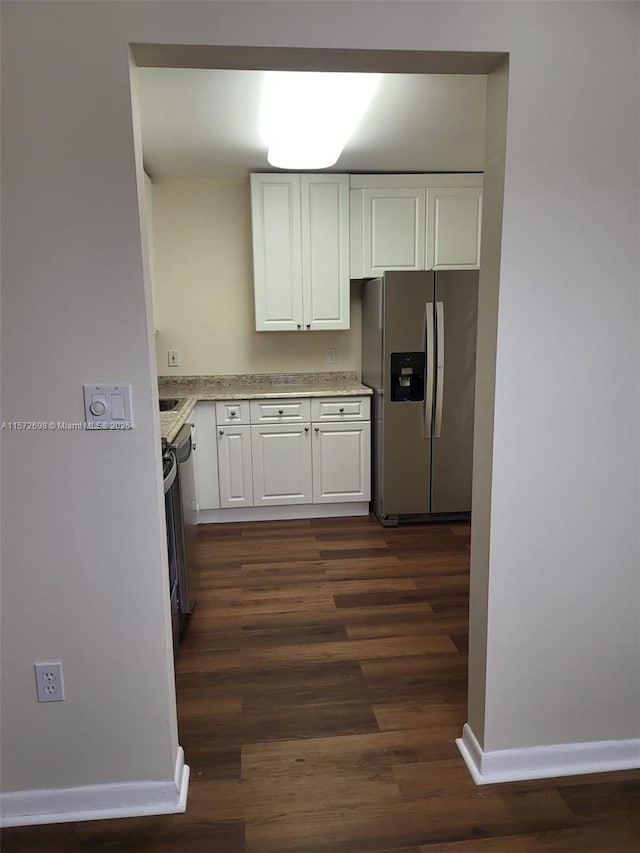 kitchen with white cabinetry, stainless steel appliances, and dark hardwood / wood-style floors