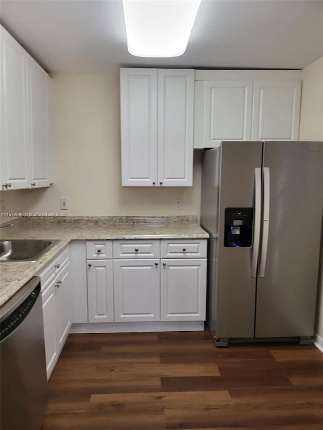 kitchen featuring white cabinets, appliances with stainless steel finishes, dark hardwood / wood-style floors, and sink