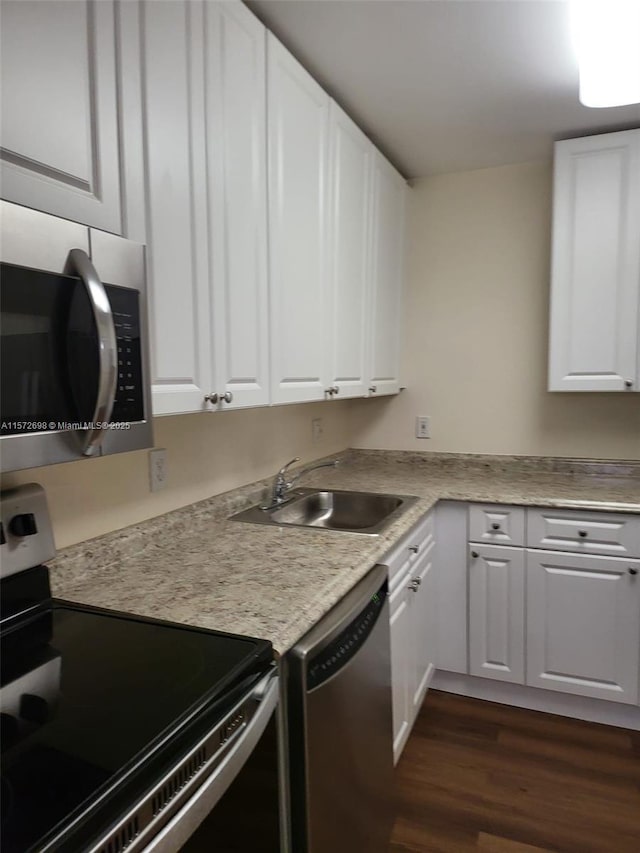 kitchen featuring white cabinets, dark hardwood / wood-style floors, sink, and appliances with stainless steel finishes