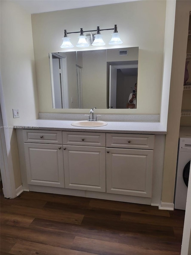 bathroom featuring vanity, wood-type flooring, and washer / dryer