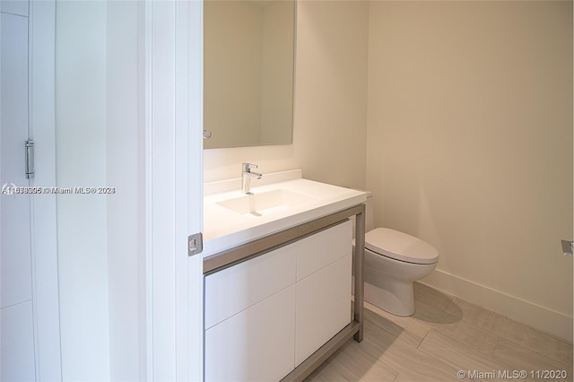 bathroom featuring toilet, tile floors, and vanity