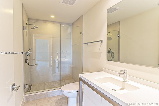 bathroom with a shower with shower door, toilet, tile flooring, and vanity