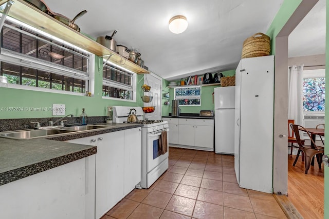 kitchen with white cabinets, white appliances, light tile flooring, and a healthy amount of sunlight