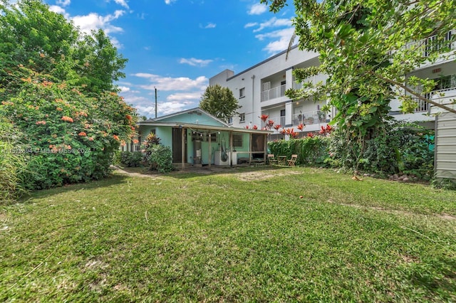 view of yard featuring a balcony and a sunroom