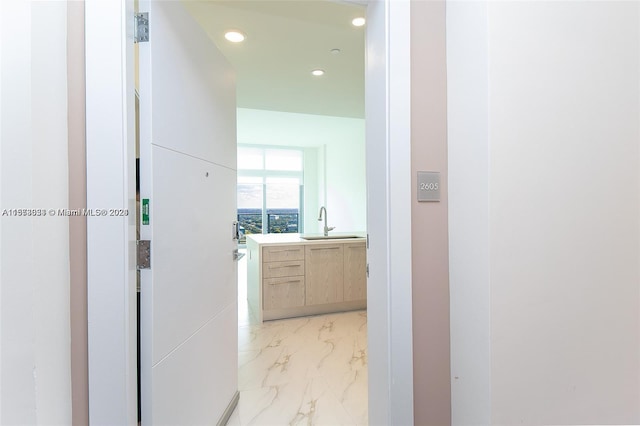 hallway featuring sink and light tile flooring