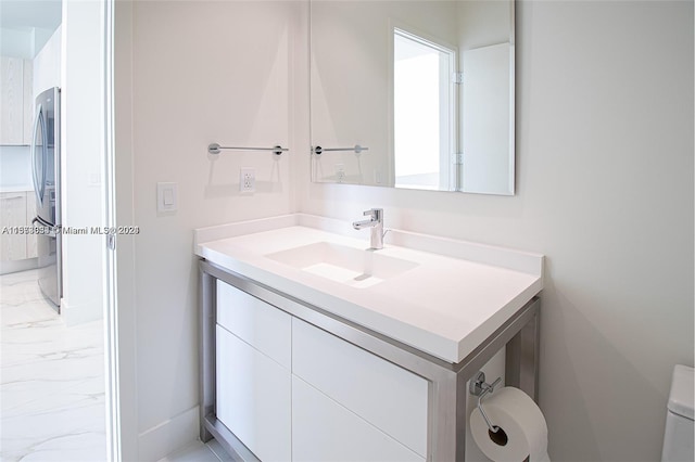 bathroom featuring vanity with extensive cabinet space, toilet, and tile flooring