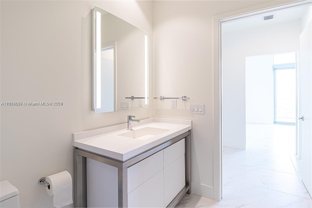 bathroom featuring vanity, tile floors, and toilet