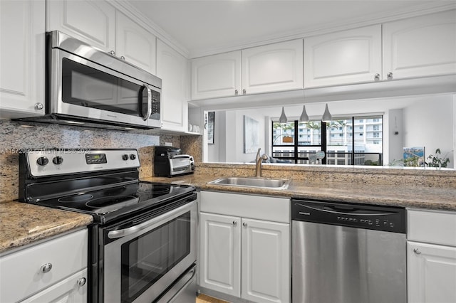 kitchen featuring backsplash, white cabinets, sink, dark stone countertops, and stainless steel appliances