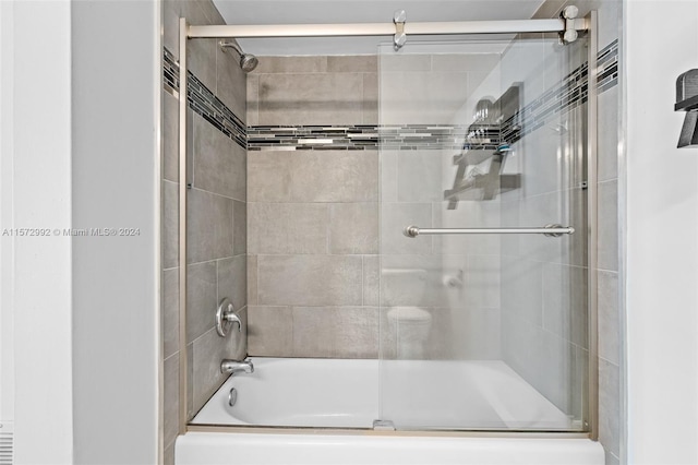 bathroom featuring bath / shower combo with glass door