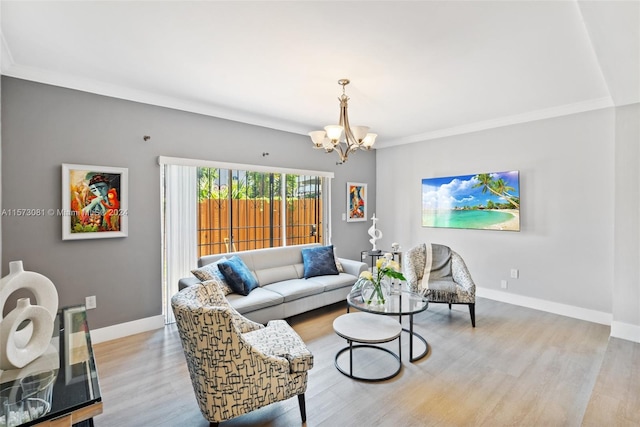 living room with an inviting chandelier, light wood-type flooring, and ornamental molding