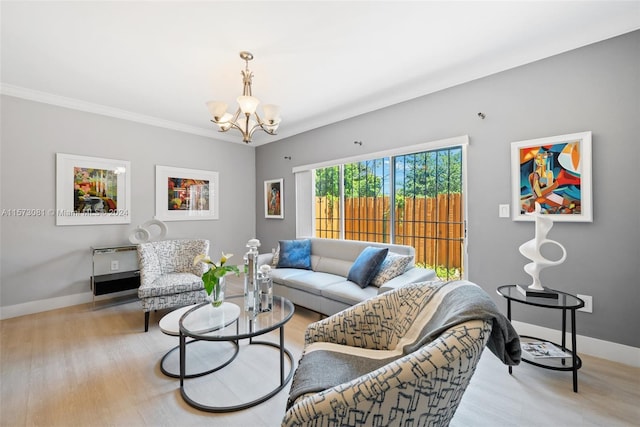 living room with light wood-type flooring, a notable chandelier, and crown molding