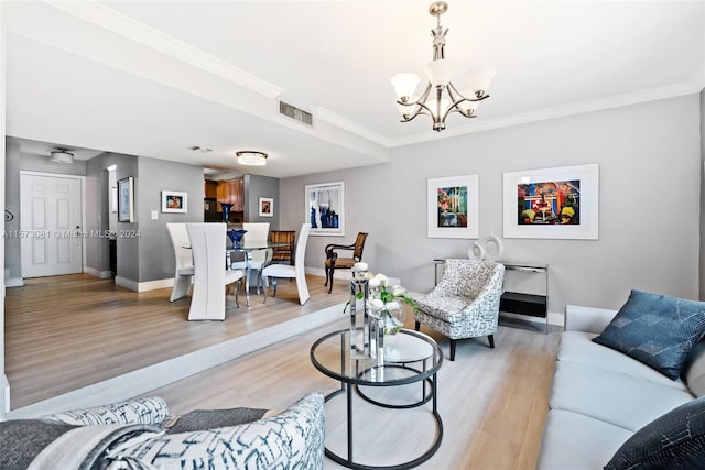 living room featuring a notable chandelier, light wood-type flooring, and crown molding