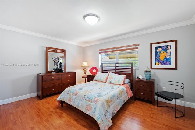 bedroom with ornamental molding and light hardwood / wood-style flooring