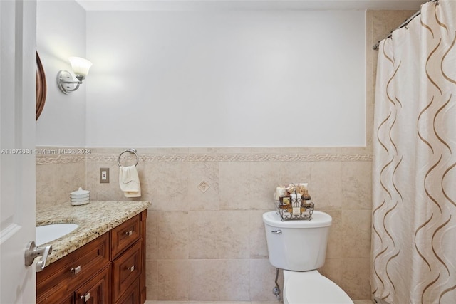 bathroom featuring vanity, tile walls, toilet, and walk in shower