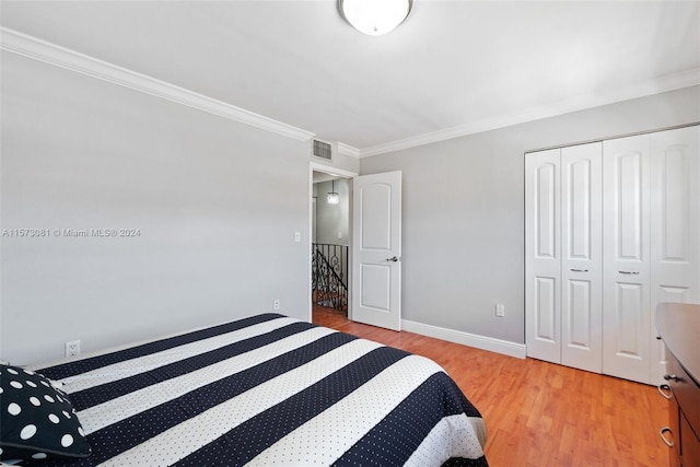 bedroom featuring a closet, ornamental molding, and light hardwood / wood-style flooring