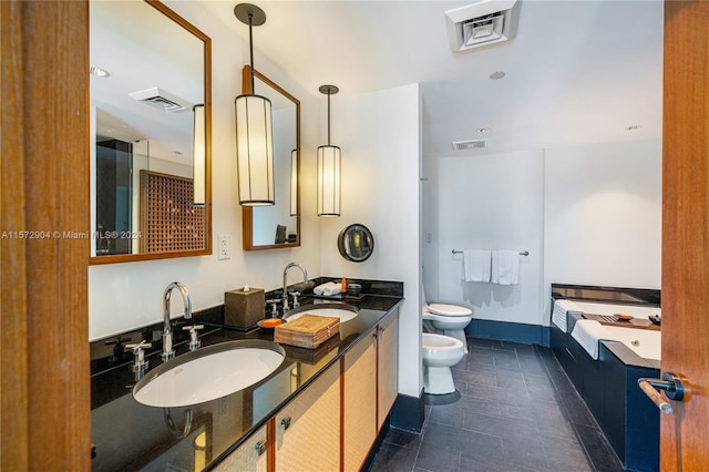 bathroom with tile patterned flooring, vanity, toilet, and a bidet