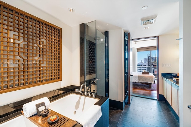 bathroom with tile patterned flooring, a bath, and vanity