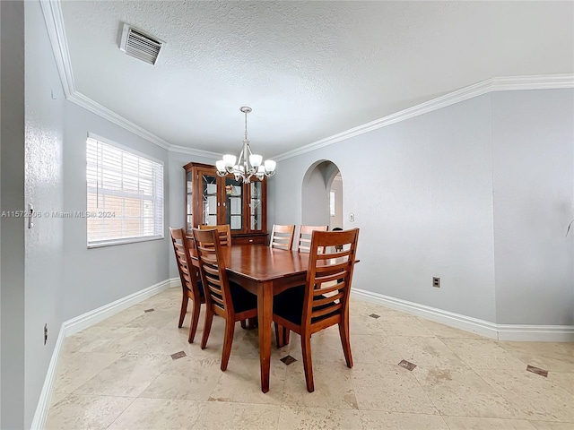 dining room with a textured ceiling, crown molding, and a notable chandelier