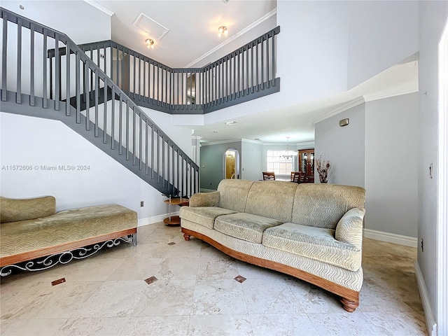 living room with decorative columns, a notable chandelier, a high ceiling, and ornamental molding