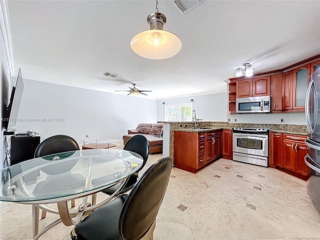 kitchen with ceiling fan, sink, hanging light fixtures, a textured ceiling, and appliances with stainless steel finishes