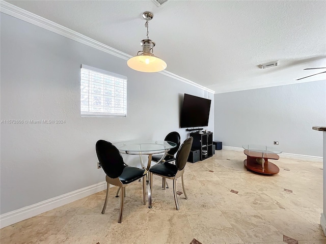 dining space featuring a textured ceiling, ceiling fan, and ornamental molding