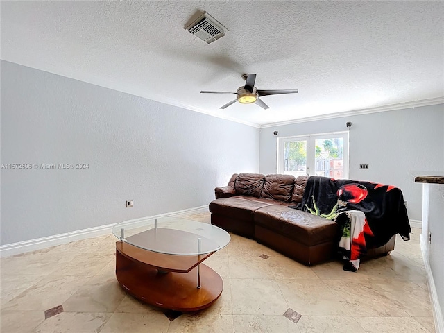 living room with a textured ceiling, ceiling fan, and ornamental molding