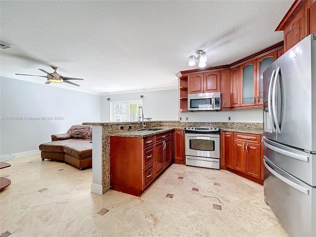 kitchen featuring sink, ceiling fan, ornamental molding, appliances with stainless steel finishes, and kitchen peninsula