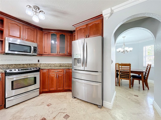 kitchen with crown molding, a textured ceiling, light stone counters, stainless steel appliances, and a chandelier