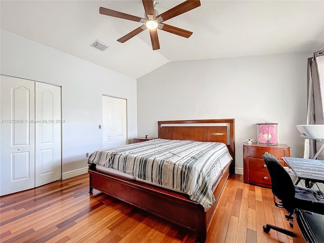 bedroom with ceiling fan, vaulted ceiling, and light wood-type flooring