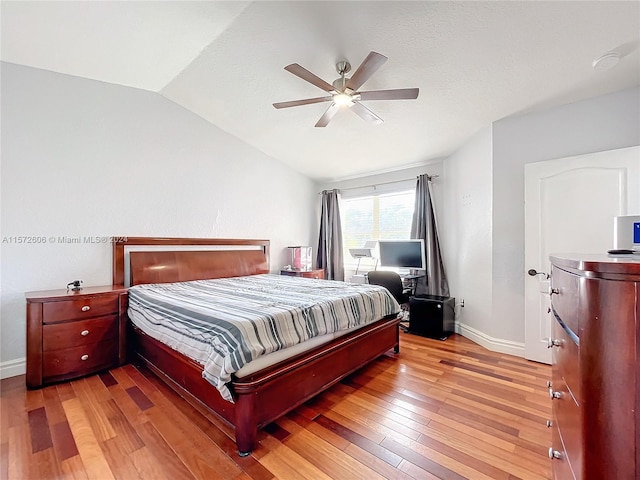 bedroom featuring ceiling fan, vaulted ceiling, and light hardwood / wood-style flooring