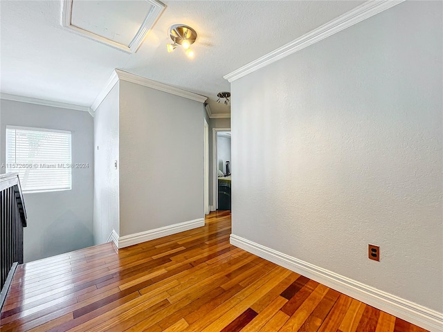 unfurnished room featuring wood-type flooring and ornamental molding