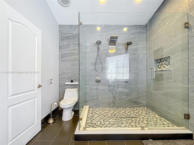 bathroom featuring an enclosed shower, tile patterned flooring, and toilet