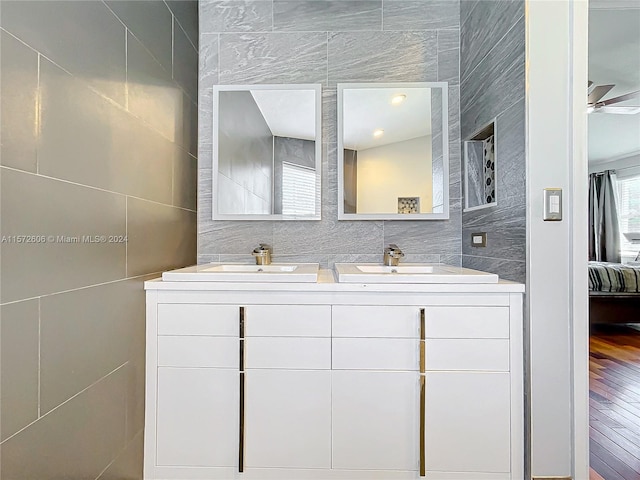 bathroom featuring ceiling fan, vanity, tile walls, and hardwood / wood-style flooring