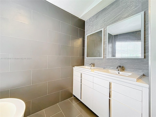 bathroom with tile patterned flooring, vanity, and tile walls