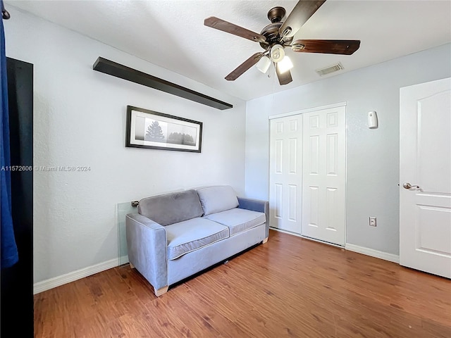 sitting room with hardwood / wood-style flooring and ceiling fan