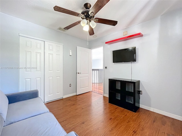 living room featuring hardwood / wood-style floors and ceiling fan