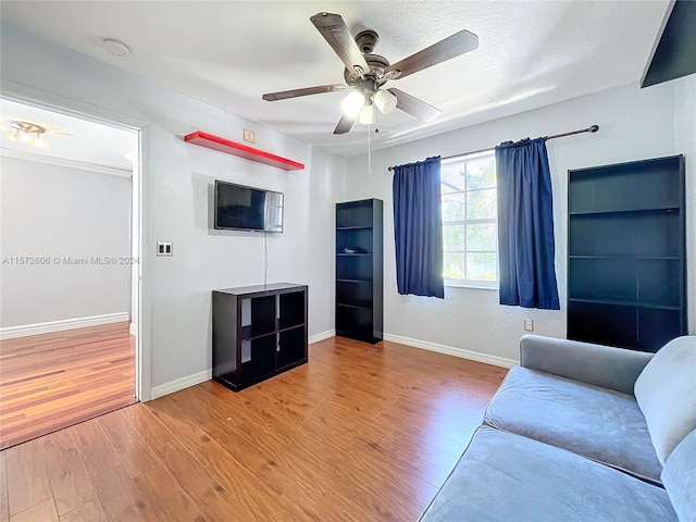 unfurnished living room with ceiling fan, a textured ceiling, and hardwood / wood-style flooring