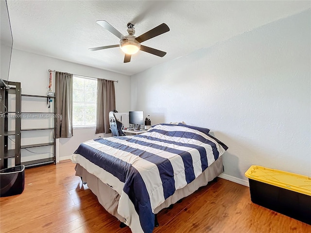 bedroom featuring ceiling fan, a textured ceiling, and hardwood / wood-style flooring