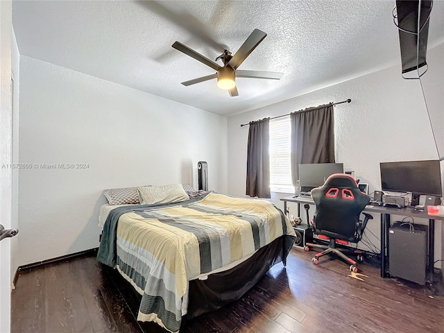 bedroom featuring ceiling fan, dark wood-type flooring, and a textured ceiling