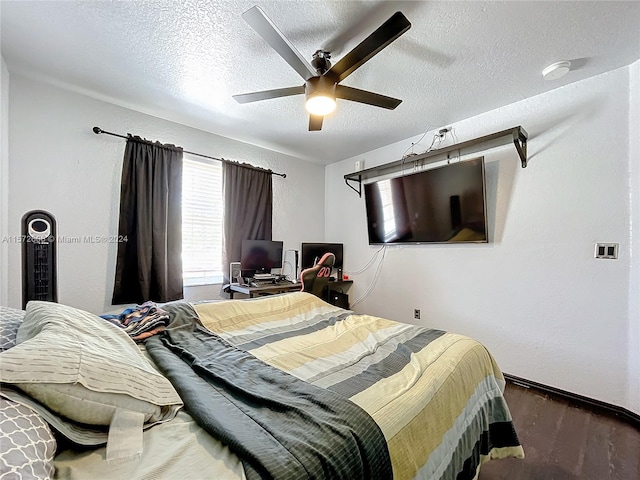 bedroom with ceiling fan, dark hardwood / wood-style floors, and a textured ceiling