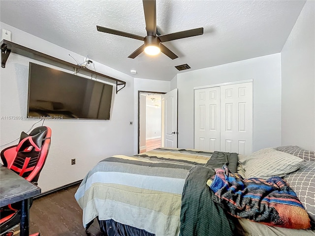 bedroom featuring ceiling fan, a closet, hardwood / wood-style floors, and a textured ceiling