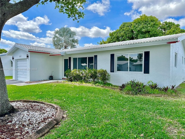 ranch-style home with a garage and a front lawn