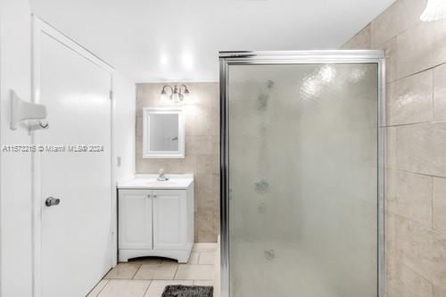 bathroom featuring tile patterned flooring, vanity, and an enclosed shower