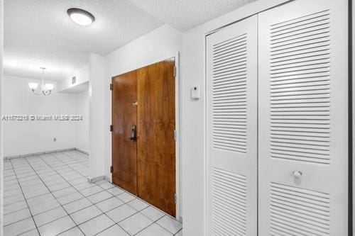 hall featuring light tile patterned floors and a chandelier