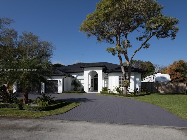 mediterranean / spanish house featuring a front lawn and a garage