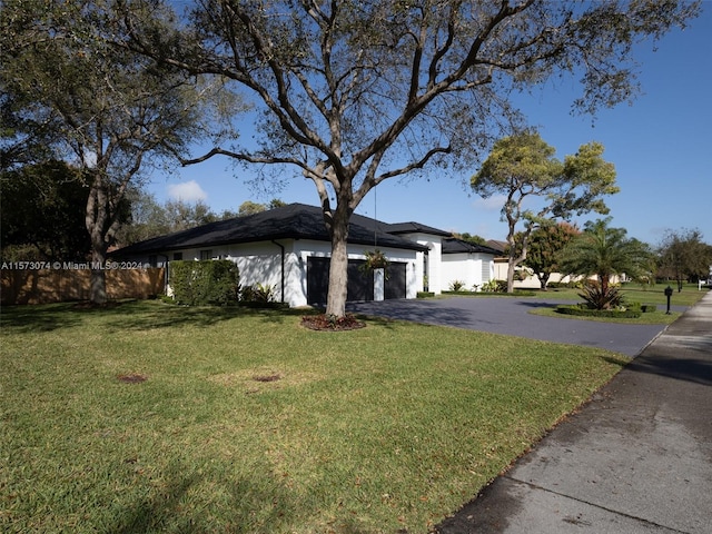 view of front of home with a front lawn and a garage