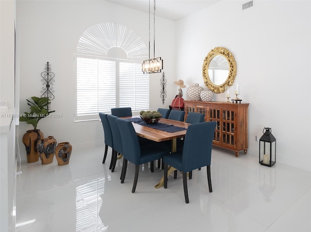 dining space with light tile floors and an inviting chandelier