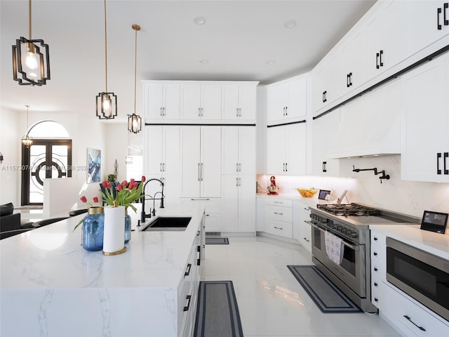 kitchen featuring light stone countertops, stainless steel appliances, white cabinets, sink, and light tile floors