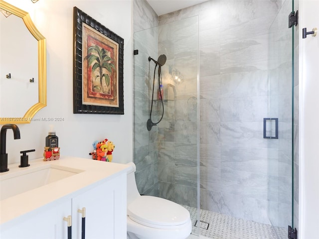 bathroom with vanity, toilet, and a shower with shower door